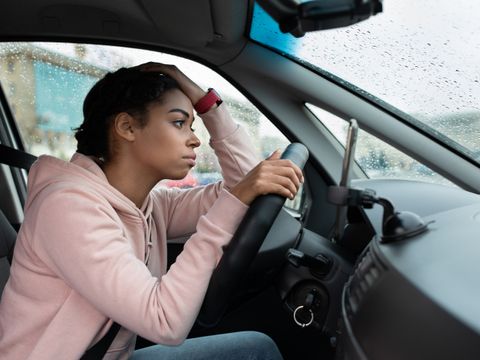 Frau am Steuer eines Autos sucht einen Parkplatz